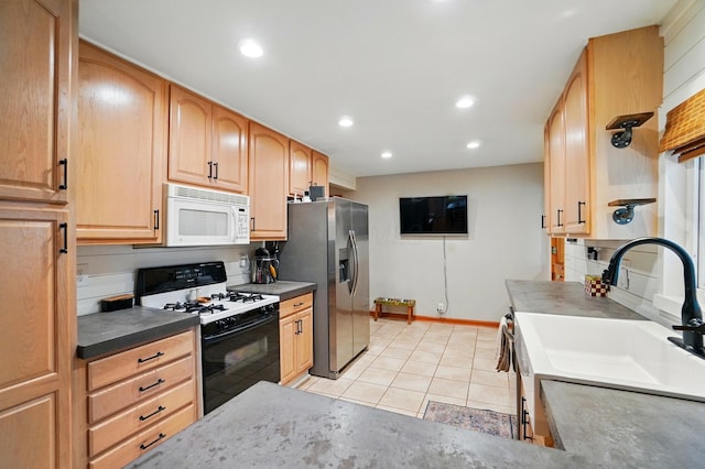 kitchen with white microwave, range with gas stovetop, stainless steel refrigerator with ice dispenser, light tile patterned floors, and light brown cabinets