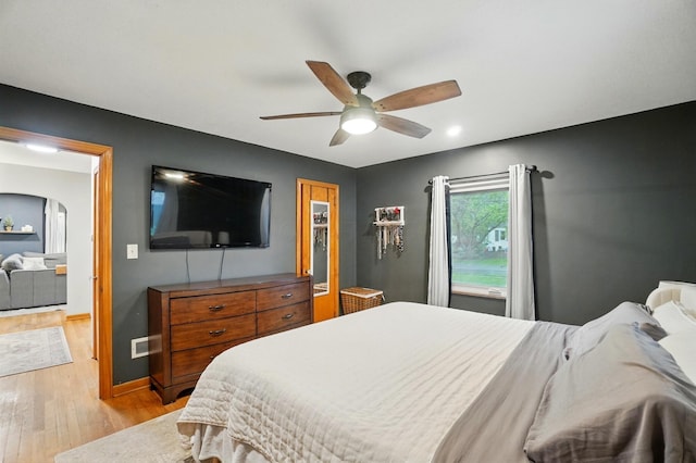 bedroom featuring light wood-style floors, baseboards, ceiling fan, recessed lighting, and arched walkways
