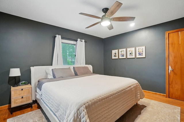 bedroom featuring wood finished floors, baseboards, and a ceiling fan