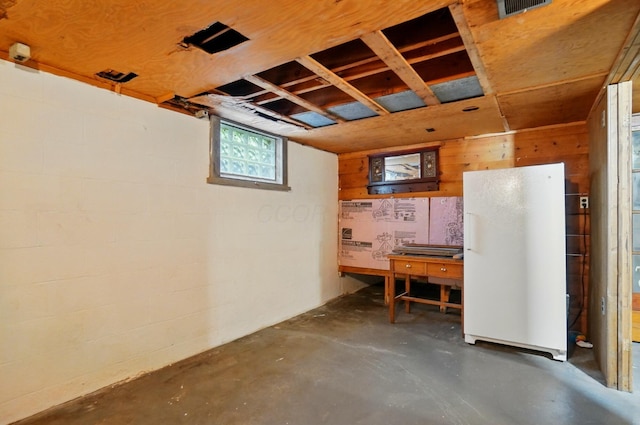 basement featuring wood walls and concrete block wall