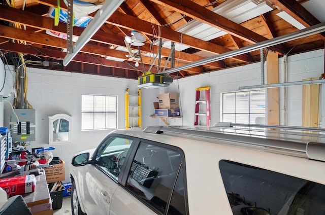 garage featuring concrete block wall and a garage door opener