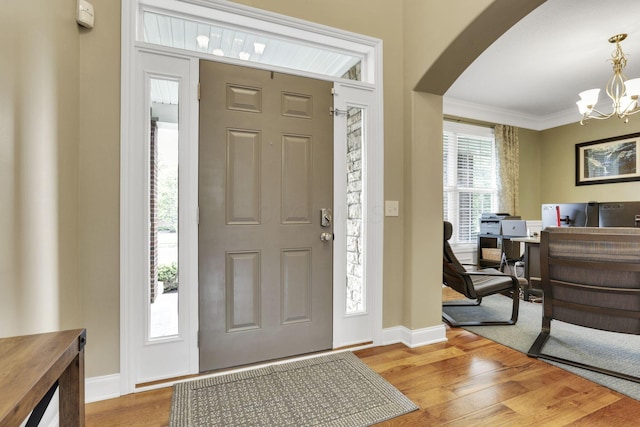 4919 Nadine Park Dr, Hilliard, OH 43026 - entryway featuring a chandelier, arched walkways, wood finished floors, ornamental molding, and baseboards