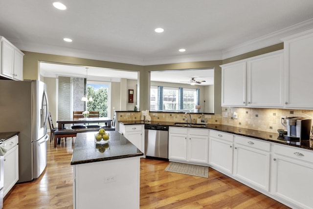4919 Nadine Park Dr, Hilliard, OH 43026 - kitchen featuring stainless steel appliances, a sink, crown molding, plenty of natural light, and a kitchen island