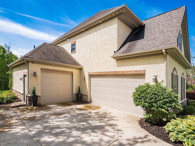 9378 Pine Creek Dr, Powell, OH 43065 - view of side of home featuring stucco siding, concrete driveway, and a shingled roof