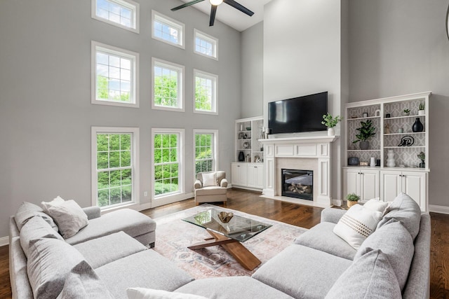 9378 Pine Creek Dr, Powell, OH 43065 - living room with a high ceiling, a ceiling fan, a fireplace, and wood finished floors