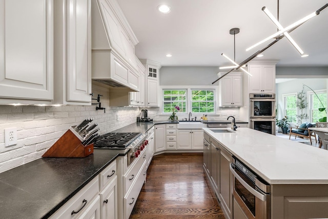 9378 Pine Creek Dr, Powell, OH 43065 - kitchen with custom range hood, stainless steel appliances, recessed lighting, healthy amount of natural light, and a sink