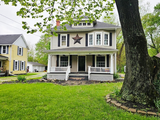 american foursquare style home featuring a porch, a front lawn, and a chimney