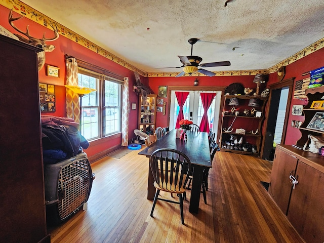 dining area with hardwood / wood-style flooring, a ceiling fan, and a textured ceiling