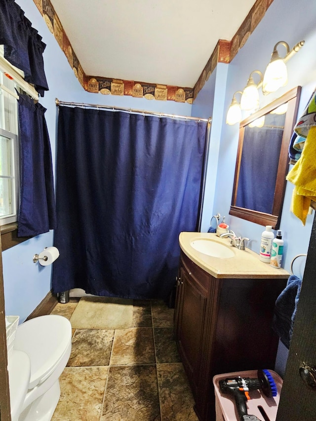 full bath with stone finish flooring, vanity, toilet, and a shower with curtain