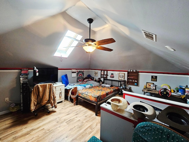 bedroom featuring vaulted ceiling, wood finished floors, a skylight, and ceiling fan
