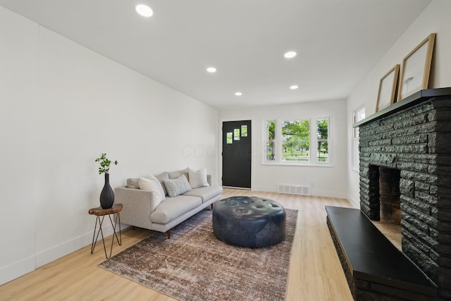 living area featuring wood finished floors, recessed lighting, a fireplace, and baseboards