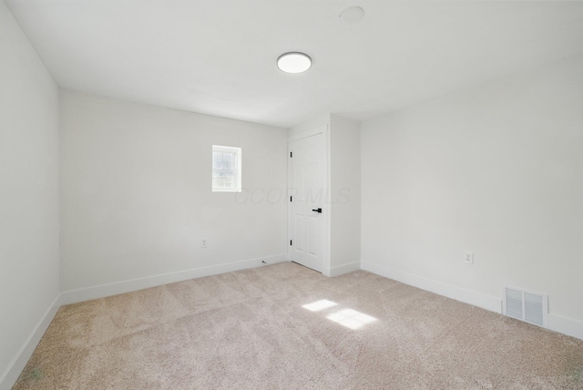 unfurnished room with light carpet and baseboards