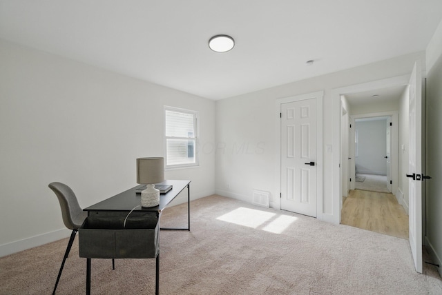 carpeted home office with baseboards