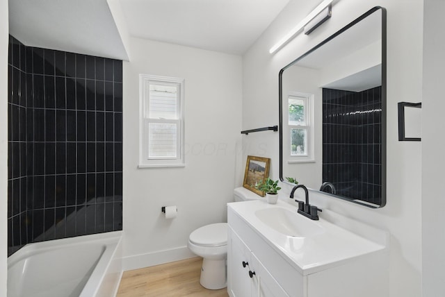 bathroom with healthy amount of natural light, baseboards, vanity, and toilet