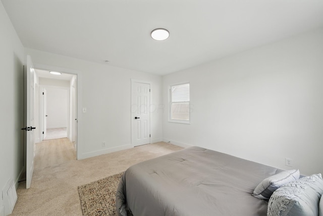 bedroom featuring light colored carpet and baseboards