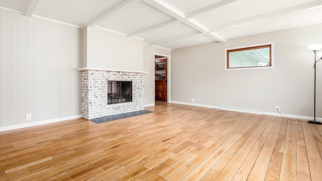 255 S Preston St, Centerburg, OH 43011 - unfurnished living room featuring beamed ceiling, light wood-style flooring, a brick fireplace, baseboards, and coffered ceiling