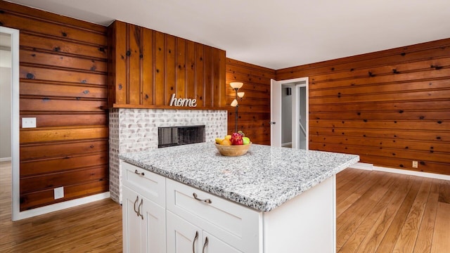 255 S Preston St, Centerburg, OH 43011 - kitchen with light wood finished floors, light stone countertops, wooden walls, and white cabinetry