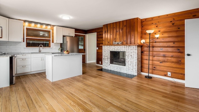 255 S Preston St, Centerburg, OH 43011 - kitchen with freestanding refrigerator, a sink, a center island, white cabinetry, and light wood-style flooring