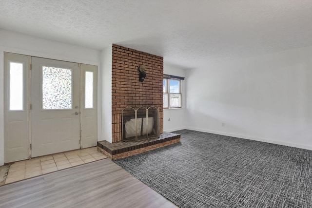 315 Redmond Rd, Columbus, OH 43228 - foyer entrance with a textured ceiling, a fireplace, wood finished floors, and baseboards