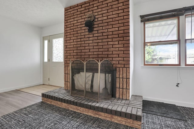 315 Redmond Rd, Columbus, OH 43228 - detailed view of a brick fireplace, wood finished floors, a textured ceiling, and baseboards