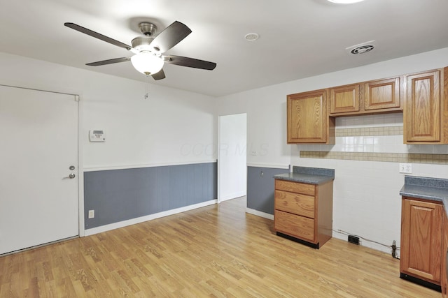 315 Redmond Rd, Columbus, OH 43228 - kitchen with ceiling fan, light wood-style floors, wainscoting, dark countertops, and brown cabinets