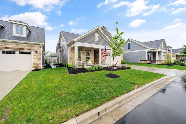 6678 Trinity Mist Way, Delaware, OH 43015 - view of front of home with covered porch, a front yard, a garage, stone siding, and roof with shingles