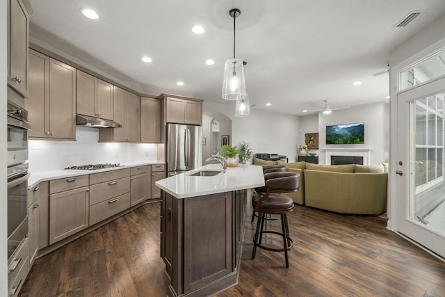 6678 Trinity Mist Way, Delaware, OH 43015 - kitchen with freestanding refrigerator, a sink, under cabinet range hood, open floor plan, and a breakfast bar area