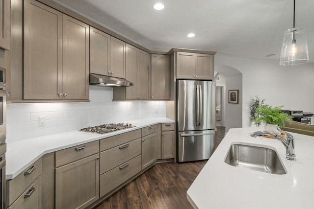 6678 Trinity Mist Way, Delaware, OH 43015 - kitchen featuring appliances with stainless steel finishes, under cabinet range hood, a sink, arched walkways, and light countertops