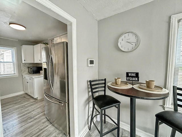 2322 Mecca Rd, Columbus, OH 43224 - kitchen with stainless steel appliances, baseboards, light wood finished floors, white cabinets, and light countertops