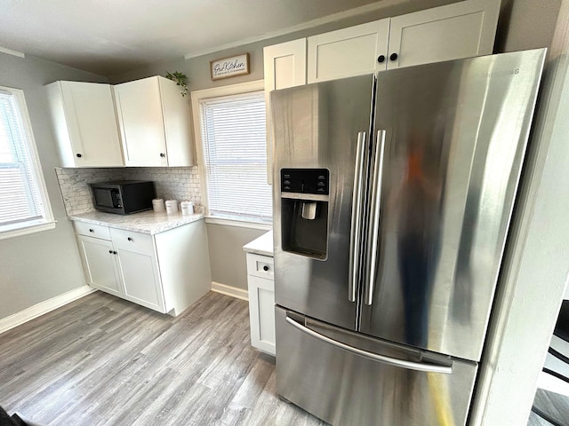 2322 Mecca Rd, Columbus, OH 43224 - kitchen featuring stainless steel fridge, black microwave, healthy amount of natural light, and white cabinets