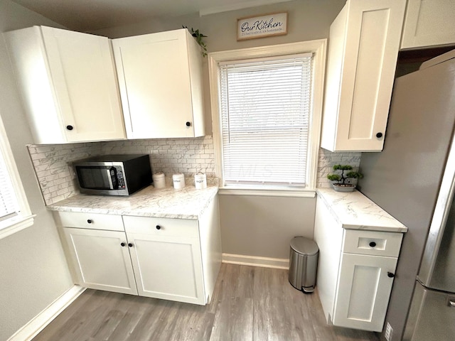 2322 Mecca Rd, Columbus, OH 43224 - kitchen with stainless steel appliances, light wood-style flooring, decorative backsplash, and baseboards