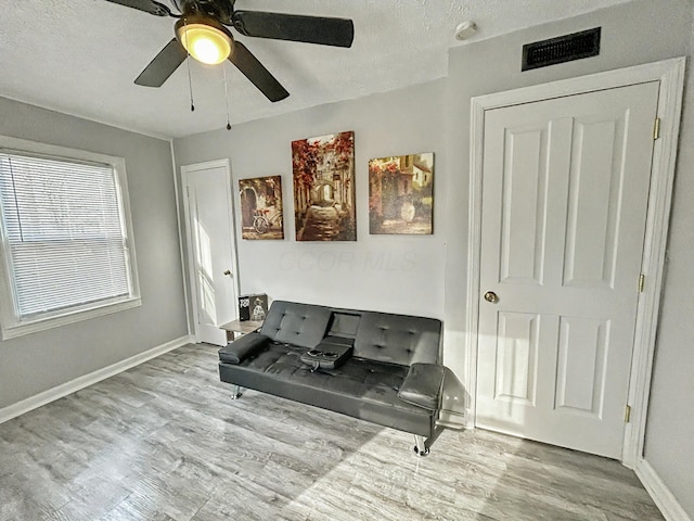 2322 Mecca Rd, Columbus, OH 43224 - sitting room with wood finished floors, baseboards, a ceiling fan, and a textured ceiling