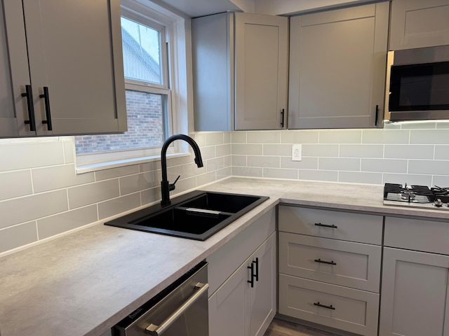 5904 Hallworth Ave Unit B, Columbus, OH 43232 - kitchen with appliances with stainless steel finishes, a sink, decorative backsplash, light countertops, and gray cabinetry