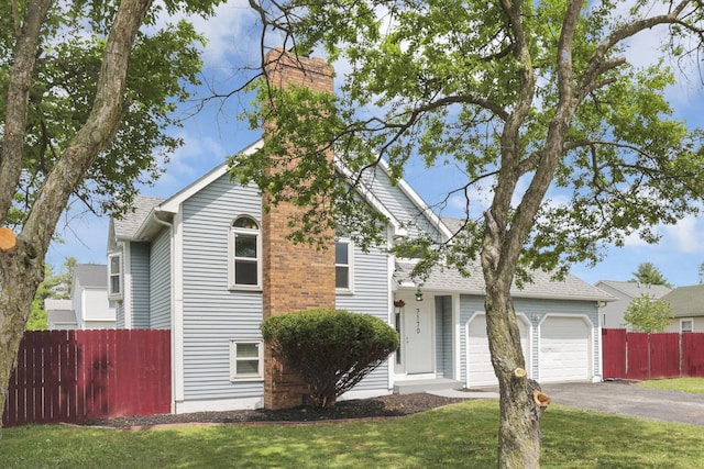 7170 Daugherty Dr, Reynoldsburg, OH 43068 - view of front of home featuring asphalt driveway, a chimney, a garage, and roof with shingles