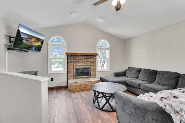 7170 Daugherty Dr, Reynoldsburg, OH 43068 - living room with healthy amount of natural light, wood finished floors, lofted ceiling, ceiling fan, and a fireplace