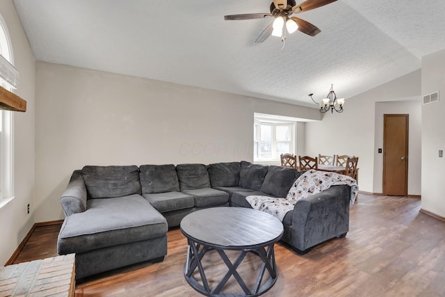 7170 Daugherty Dr, Reynoldsburg, OH 43068 - living room featuring a chandelier, wood finished floors, ceiling fan, vaulted ceiling, and a textured ceiling