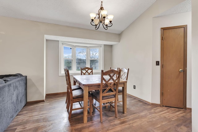 7170 Daugherty Dr, Reynoldsburg, OH 43068 - dining area featuring a chandelier, wood finished floors, baseboards, a textured ceiling, and lofted ceiling