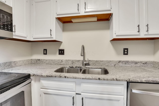7170 Daugherty Dr, Reynoldsburg, OH 43068 - kitchen featuring a sink, appliances with stainless steel finishes, white cabinetry, and light stone countertops