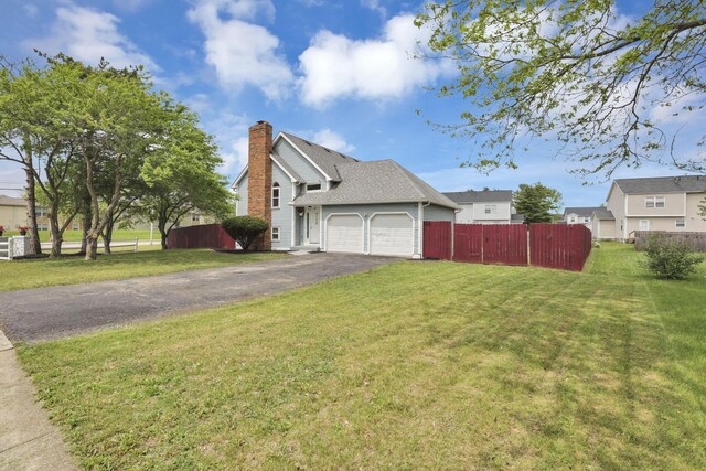 7170 Daugherty Dr, Reynoldsburg, OH 43068 - view of side of property featuring asphalt driveway, an attached garage, and a chimney