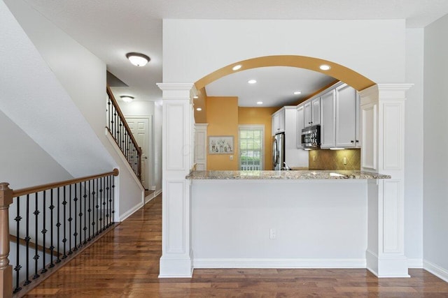 6575 Wensley Ct, Westerville, OH 43082 - kitchen featuring stainless steel appliances, dark wood finished floors, light stone countertops, white cabinets, and recessed lighting