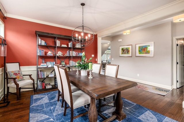 dining room featuring a chandelier, wood-type flooring, crown molding, and baseboards