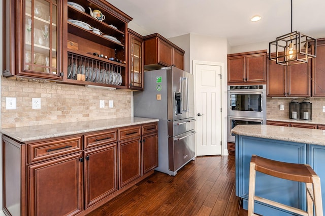 kitchen with stainless steel appliances, decorative backsplash, glass insert cabinets, light stone counters, and recessed lighting