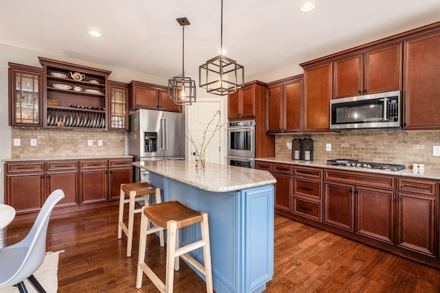 kitchen featuring appliances with stainless steel finishes, decorative backsplash, dark wood-type flooring, a kitchen bar, and recessed lighting