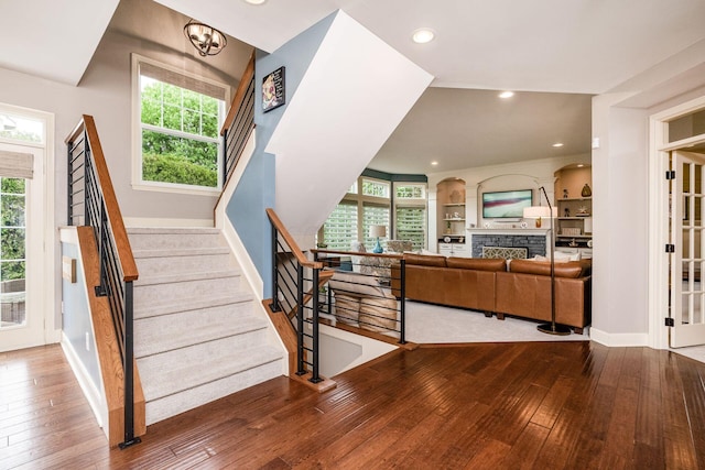 stairs with wood-type flooring, plenty of natural light, a fireplace, and recessed lighting