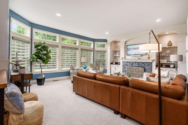 carpeted living area with a fireplace, recessed lighting, baseboards, and ornamental molding