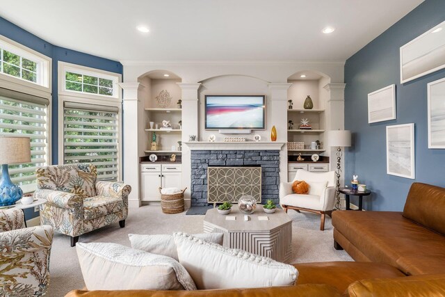 living area with light colored carpet, ornamental molding, a fireplace, recessed lighting, and ornate columns