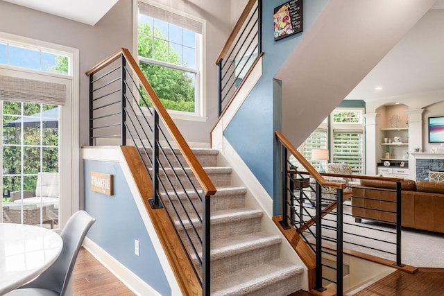 stairs with wood finished floors, baseboards, and recessed lighting