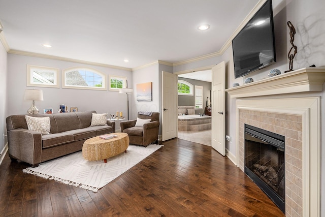 living room with a fireplace, hardwood / wood-style floors, ornamental molding, recessed lighting, and baseboards