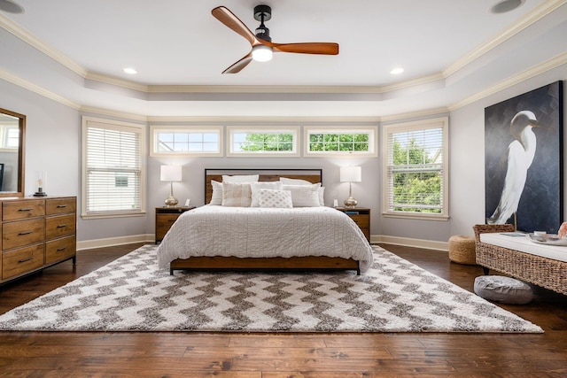 bedroom with a tray ceiling, crown molding, baseboards, and multiple windows