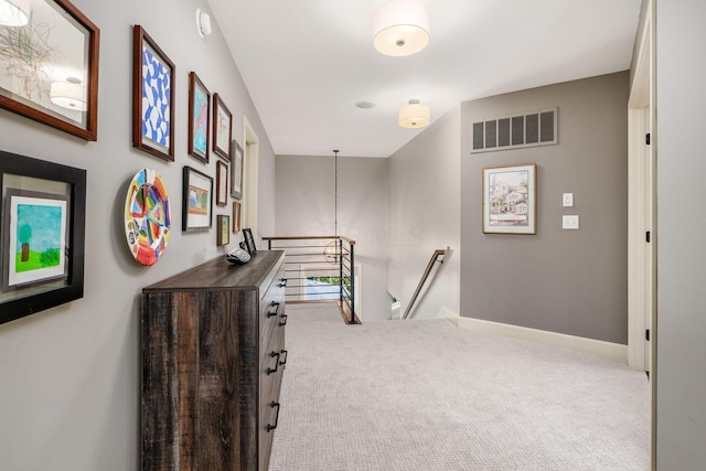 corridor featuring an upstairs landing, carpet, and baseboards